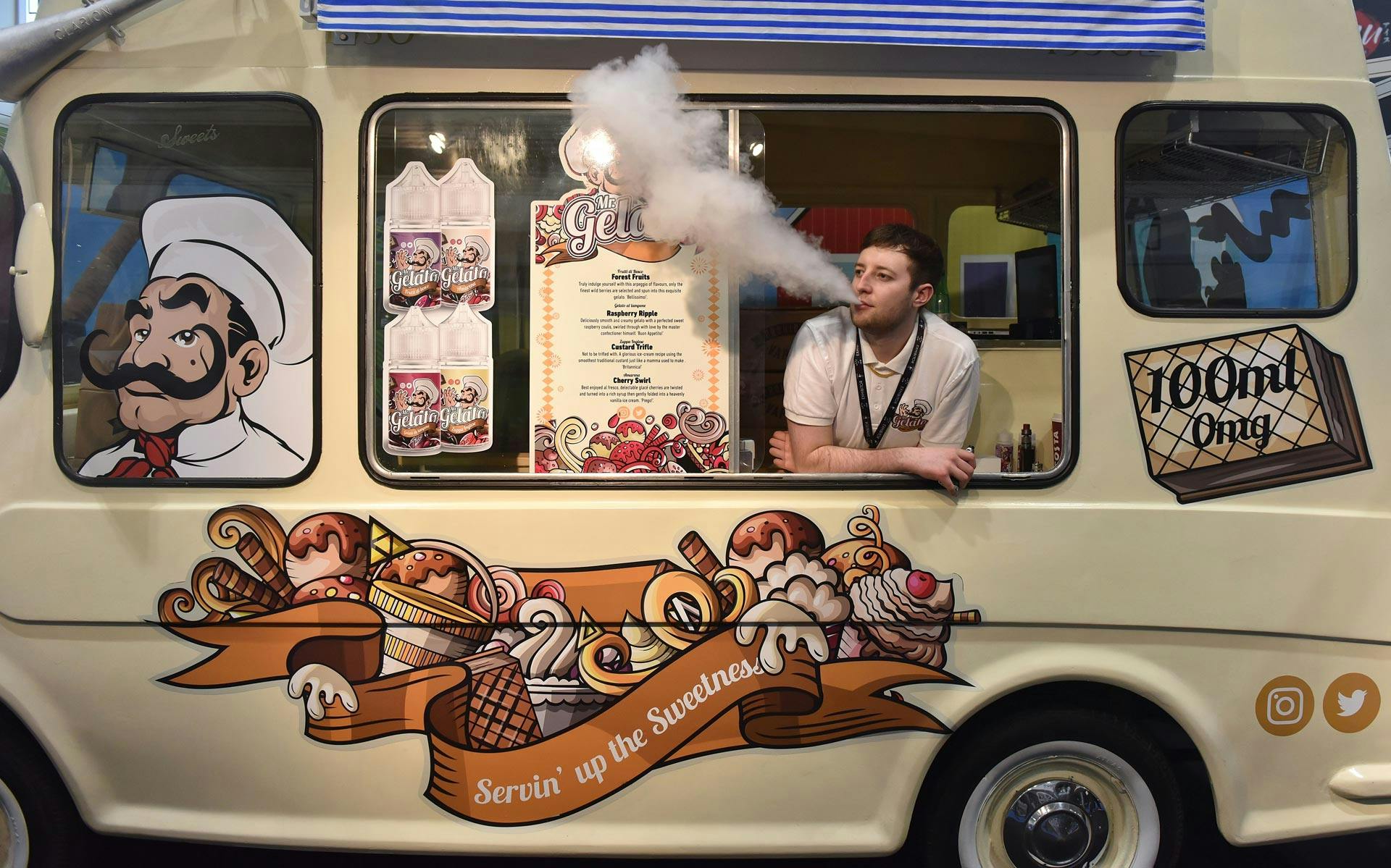 A vendor vapes in a converted ice cream van during the Vape Jam UK 4 in April 2018 in London.